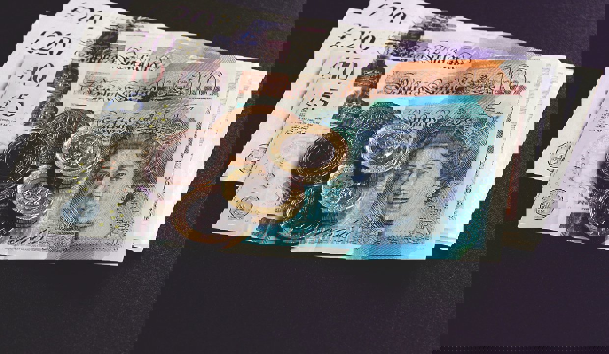 Pound coins sitting on top of bank notes