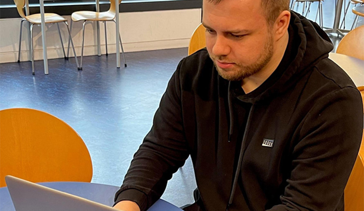 Andrew sitting at a desk with laptop