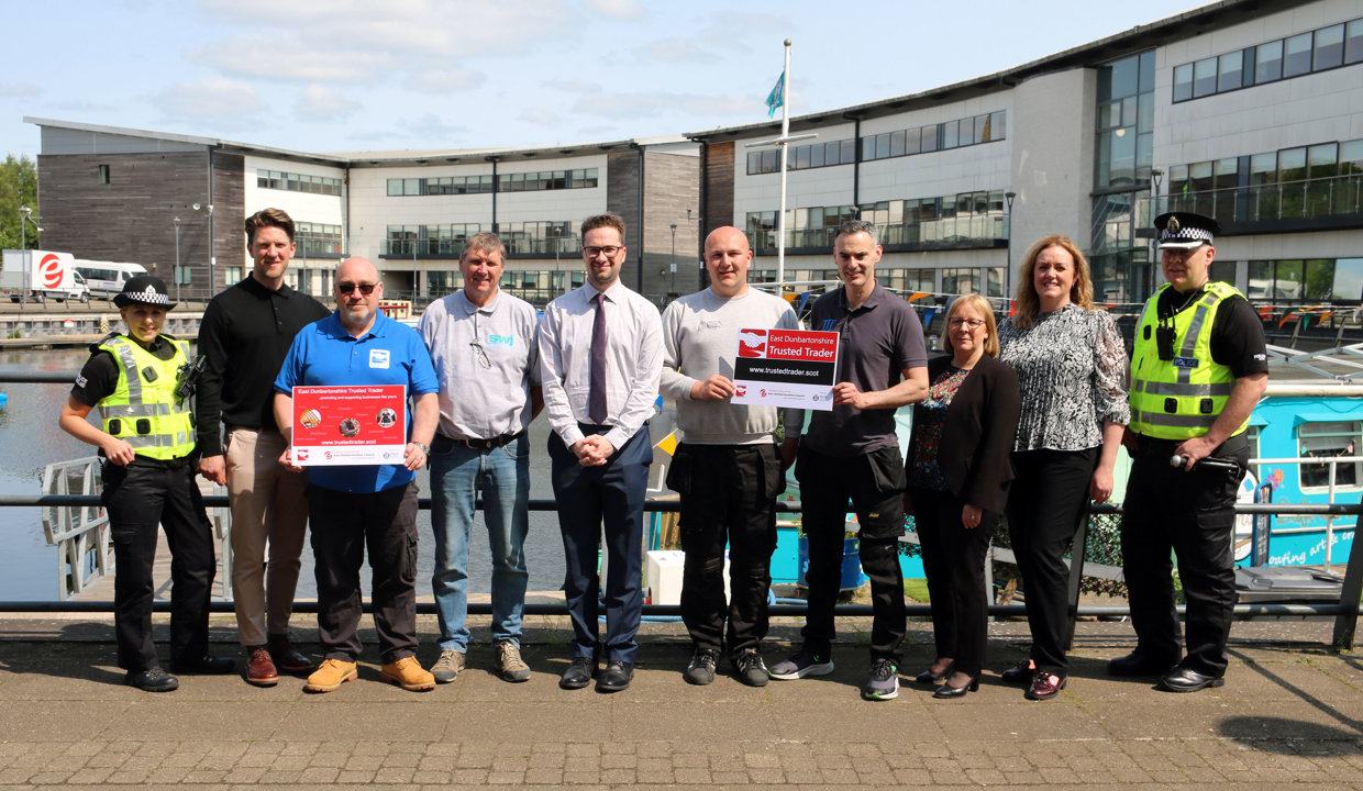 local traders, Councillor Paul Ferretti, Council Officers, representatives of Police Scotland and a representative of Trusted Trader standing outside at Kirkintilloch Marina with the canal behind them.